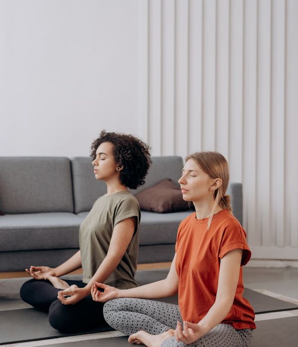 Woman in a calm yoga pose in a bright, peaceful room.